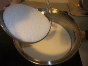 Le sucre en poudre qui tombe en pluie dans le lait qui commence à chauffer