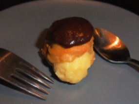 Photo d'une profiterole en comparaison à une cuillère et fourchette à dessert